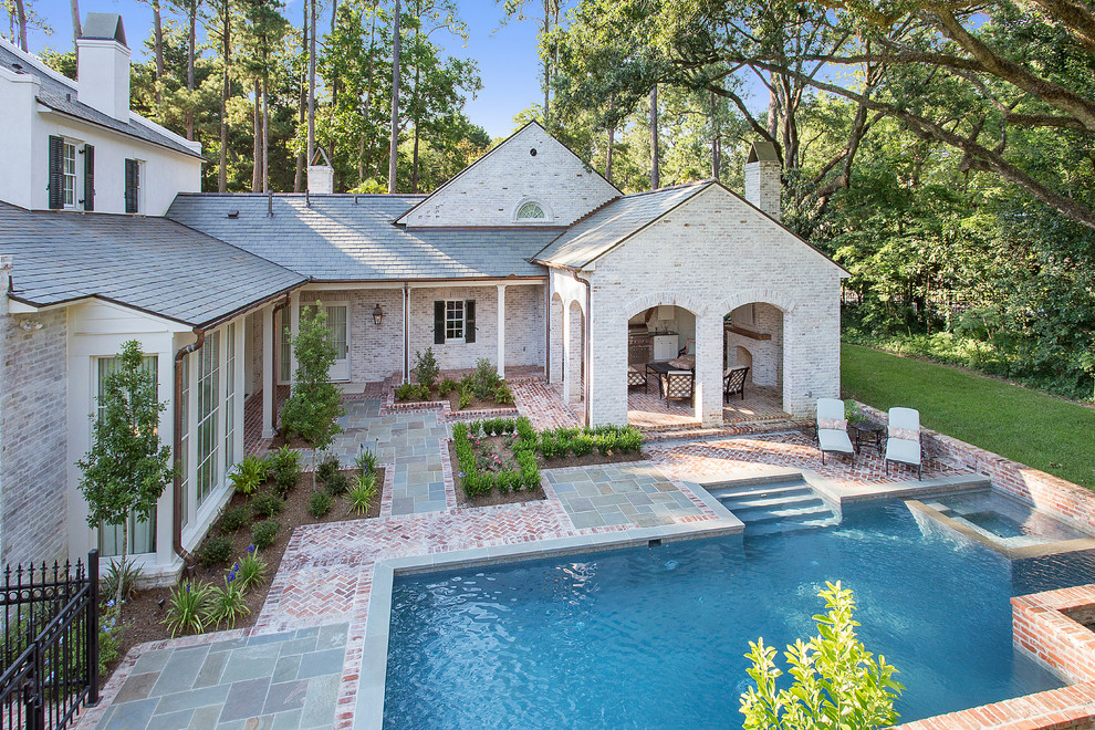Стильный дизайн: большой прямоугольный бассейн на заднем дворе в классическом стиле с джакузи и покрытием из каменной брусчатки - последний тренд