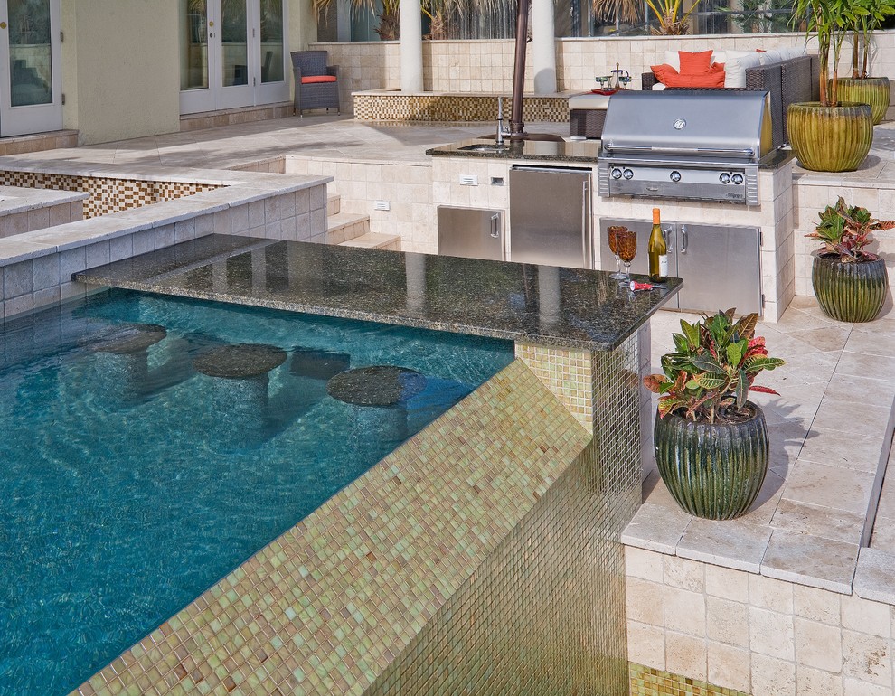 Imagen de piscina con fuente infinita actual de tamaño medio a medida en patio trasero con adoquines de piedra natural