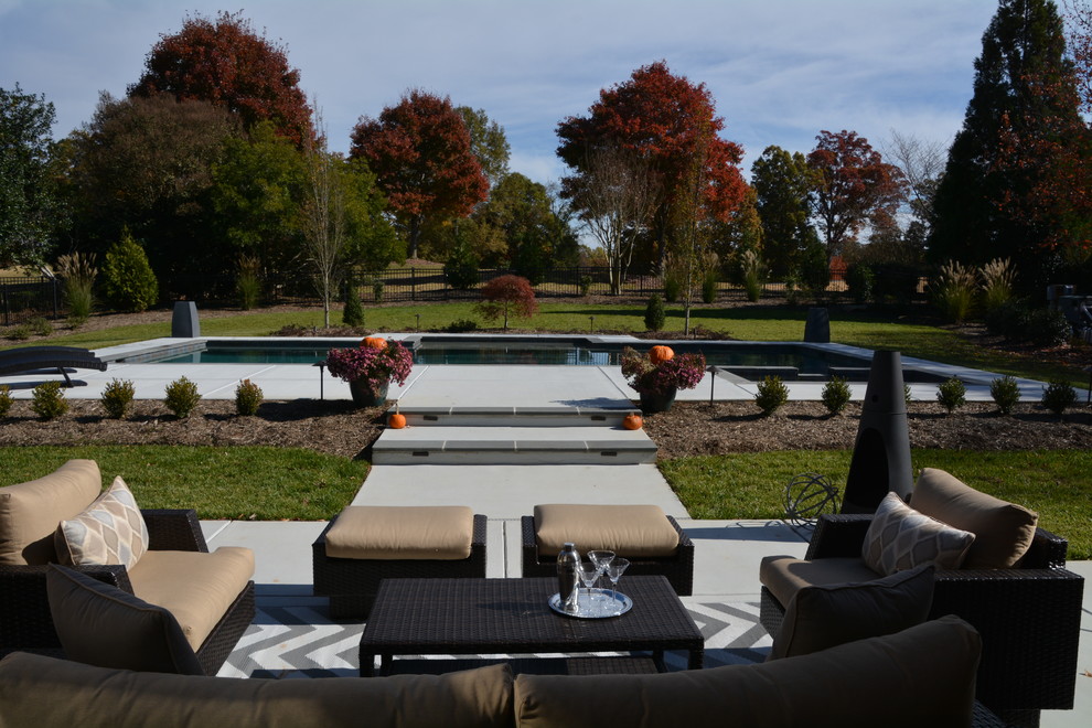 Diseño de piscinas y jacuzzis alargados modernos extra grandes rectangulares en patio trasero con adoquines de hormigón