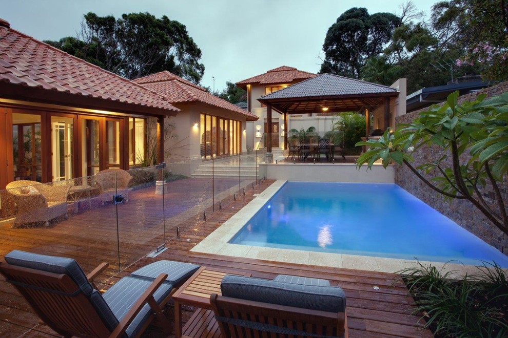 Cette photo montre une piscine arrière asiatique de taille moyenne et rectangle avec une terrasse en bois.
