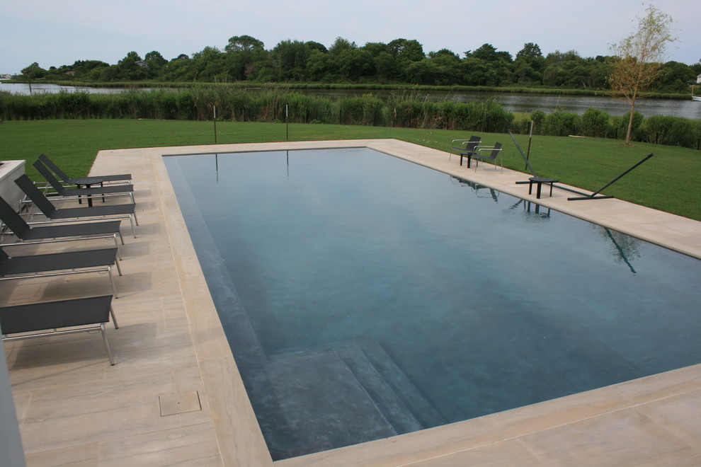 Diseño de piscinas y jacuzzis alargados actuales de tamaño medio rectangulares en patio trasero con adoquines de piedra natural