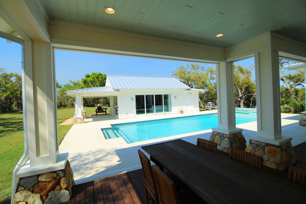 Foto di una grande piscina monocorsia tradizionale rettangolare dietro casa con una dépendance a bordo piscina