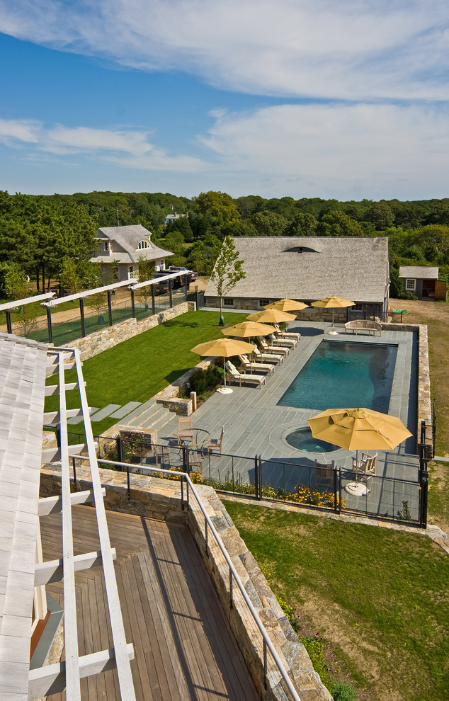 Aménagement d'un grand couloir de nage arrière campagne rectangle avec un bain bouillonnant et une terrasse en bois.