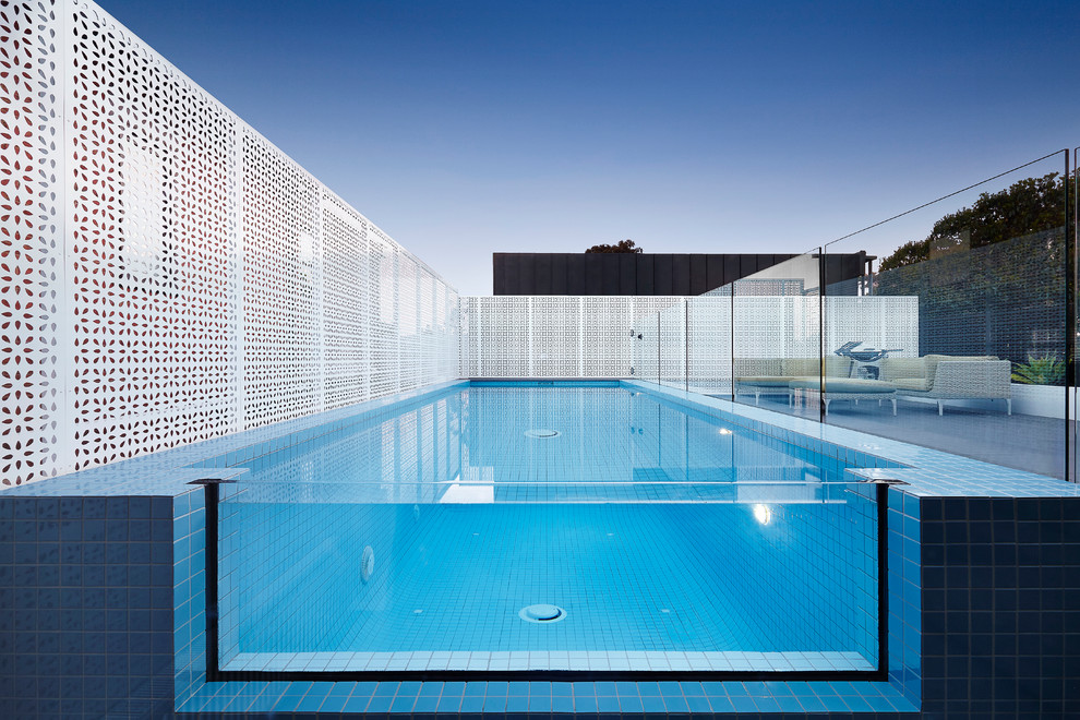 Foto de piscina alargada contemporánea rectangular con suelo de baldosas