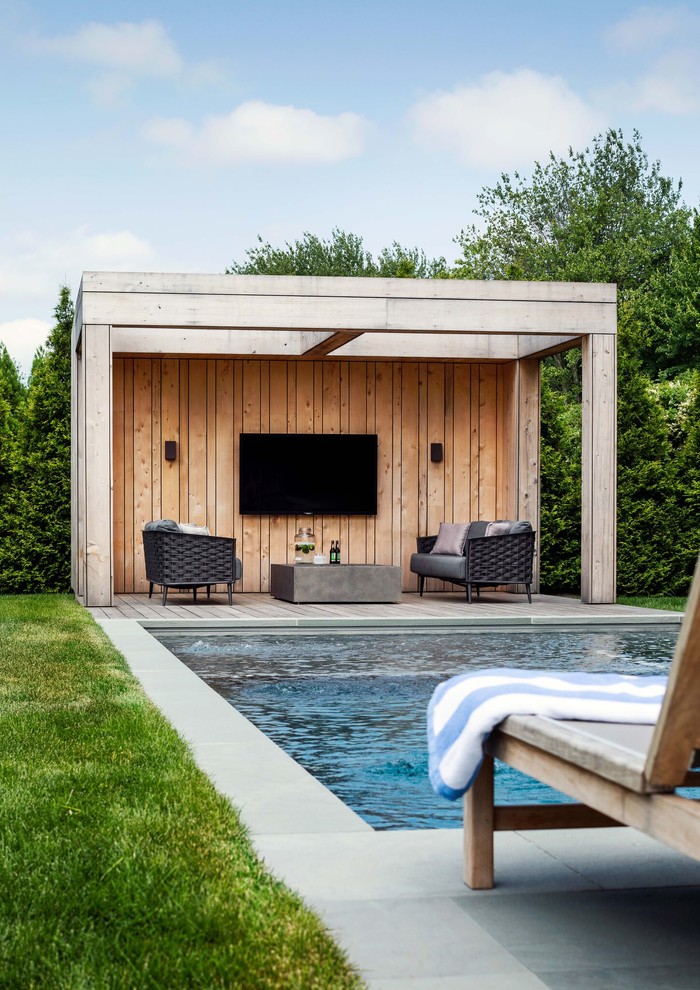 Inspiration for a farmhouse back rectangular swimming pool in New York with a pool house.