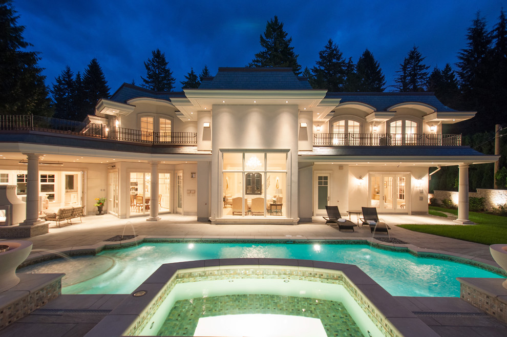 Example of a large classic backyard stone and custom-shaped natural pool fountain design in Vancouver