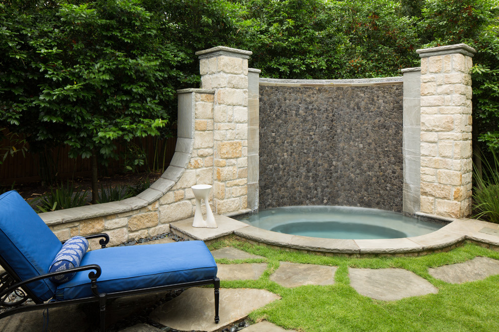 Traditional back custom shaped swimming pool in Houston with natural stone paving.
