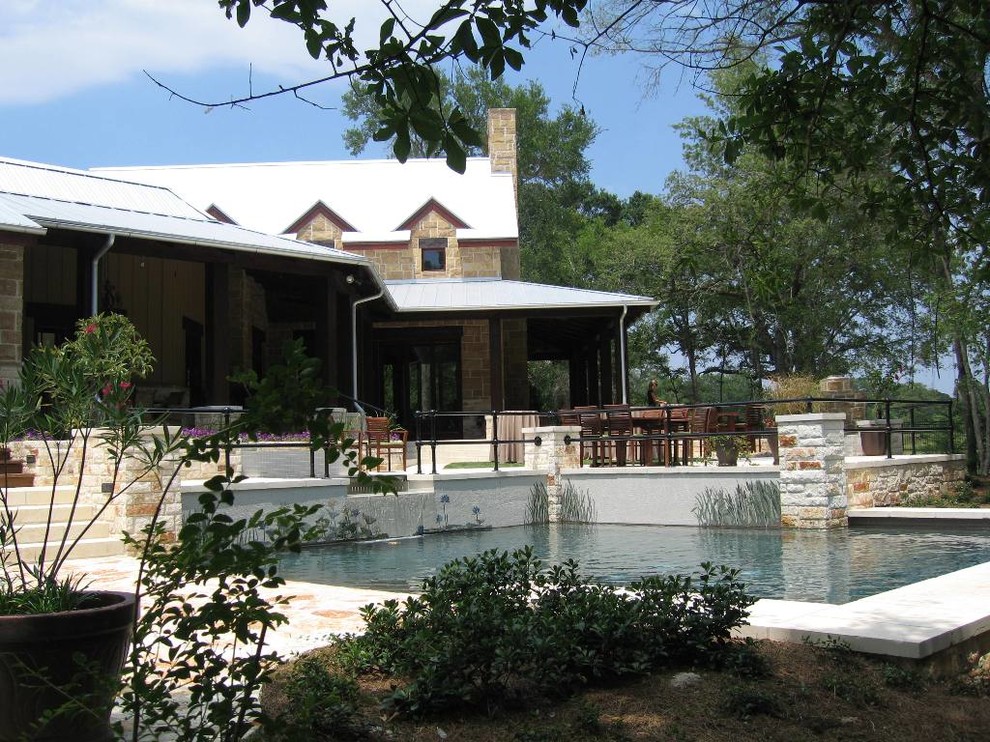 Ispirazione per una piscina naturale country rettangolare dietro casa con pavimentazioni in pietra naturale
