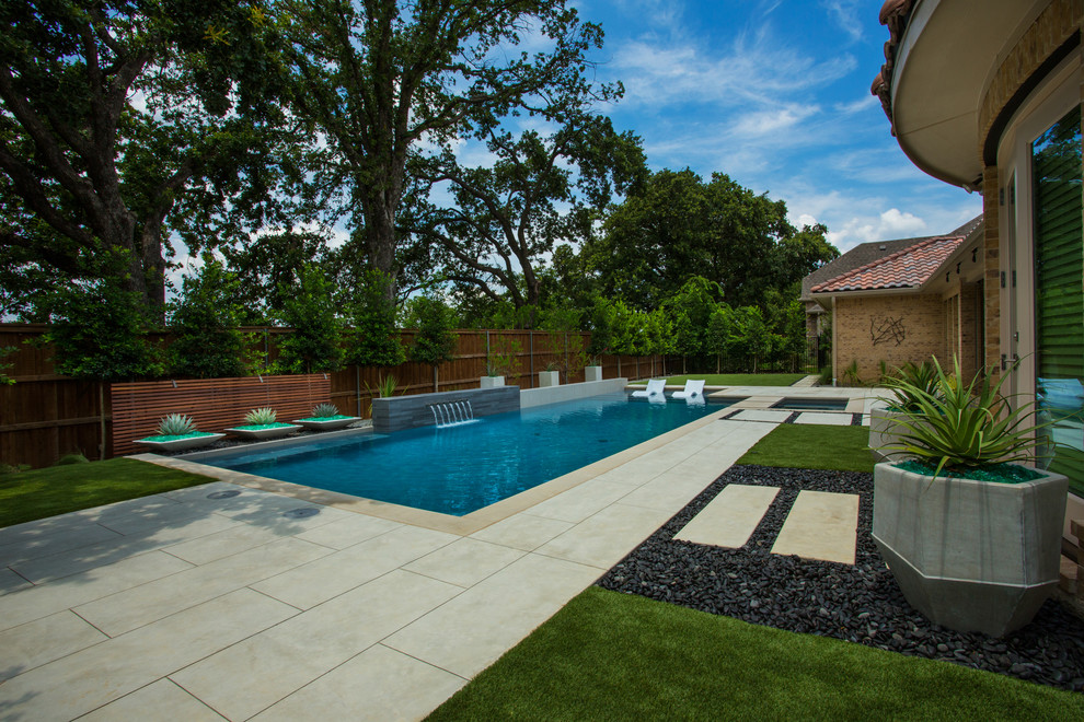 Diseño de piscina con fuente moderna de tamaño medio rectangular en patio trasero con entablado