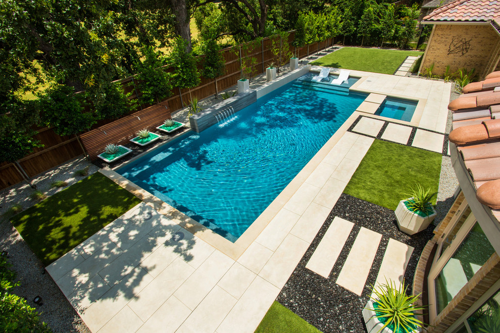 Diseño de piscina con fuente moderna de tamaño medio rectangular en patio trasero con entablado