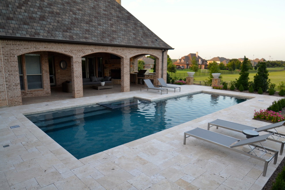 Foto de piscina actual de tamaño medio rectangular en patio trasero con adoquines de piedra natural