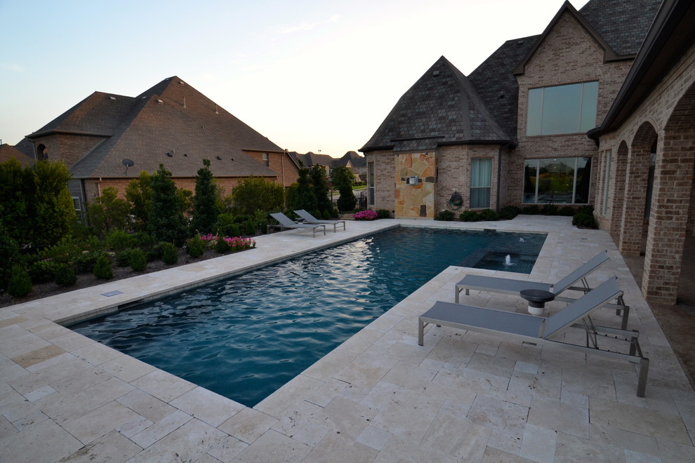 Ispirazione per una piscina minimal rettangolare di medie dimensioni e dietro casa con pavimentazioni in pietra naturale