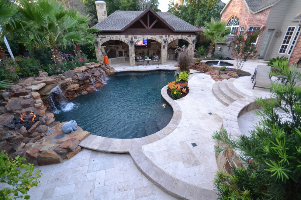 Mittelgroßer Schwimmteich hinter dem Haus in individueller Form mit Wasserspiel und Natursteinplatten in Dallas