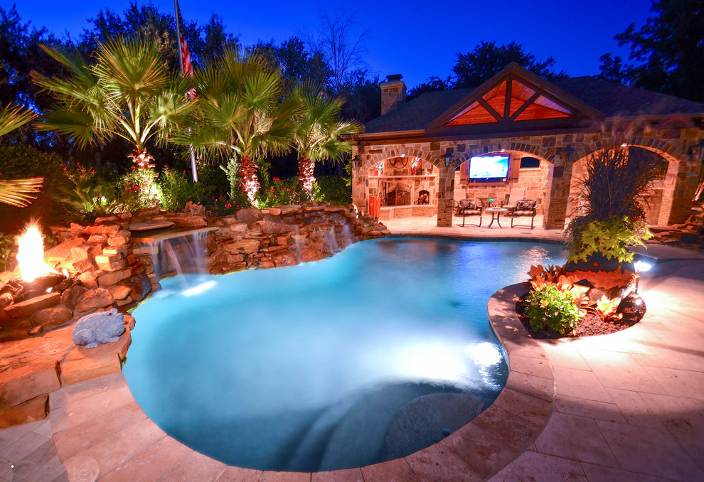 Foto di una piscina naturale tropicale personalizzata di medie dimensioni e dietro casa con una vasca idromassaggio e pavimentazioni in pietra naturale