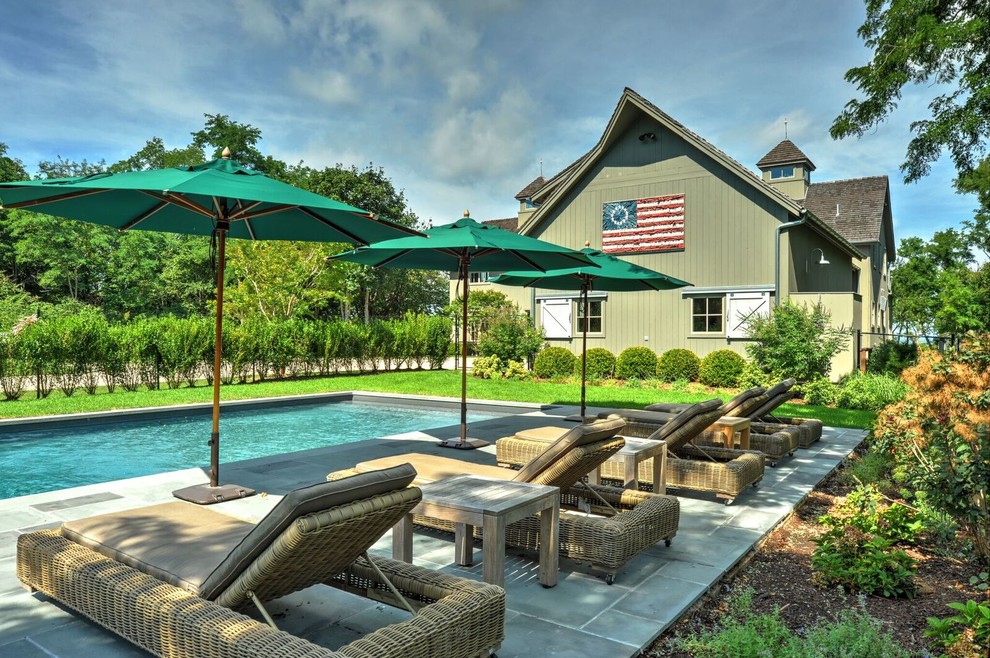 Immagine di una grande piscina monocorsia country rettangolare dietro casa con pavimentazioni in pietra naturale
