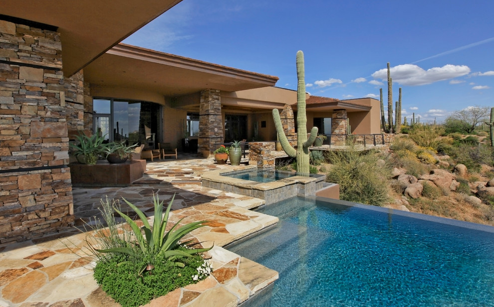 Cette image montre un grand Abris de piscine et pool houses arrière design sur mesure avec des pavés en pierre naturelle.