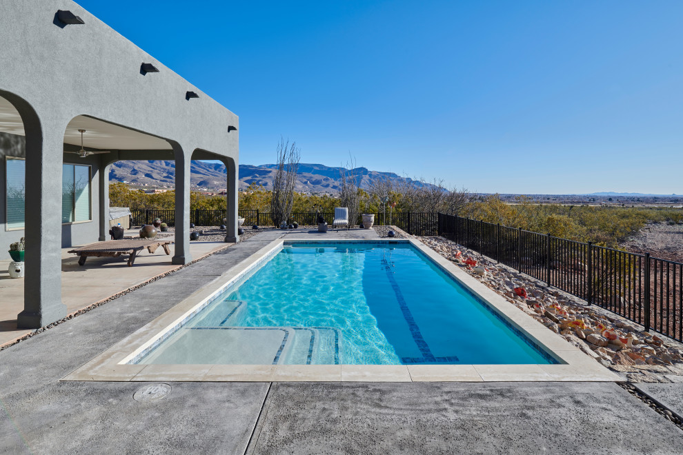 Ejemplo de piscina contemporánea de tamaño medio rectangular en patio trasero con losas de hormigón