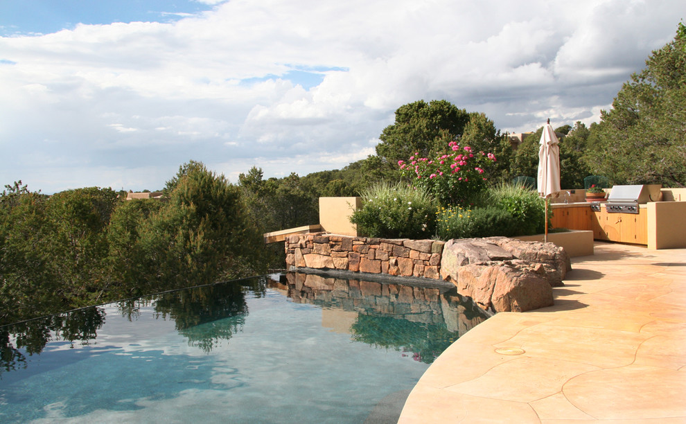 Photo of a mediterranean infinity swimming pool in Albuquerque with a bbq area.