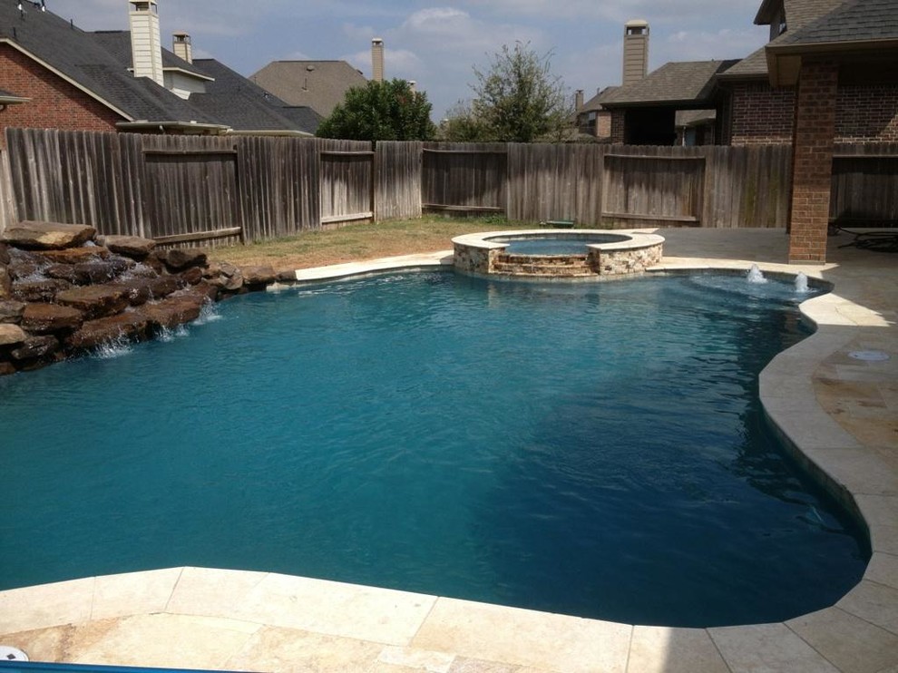Inspiration pour une grande piscine arrière sud-ouest américain sur mesure avec un point d'eau et des pavés en pierre naturelle.
