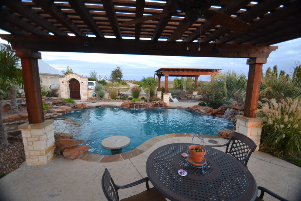 Modelo de piscina con fuente natural de estilo americano de tamaño medio a medida en patio con adoquines de hormigón