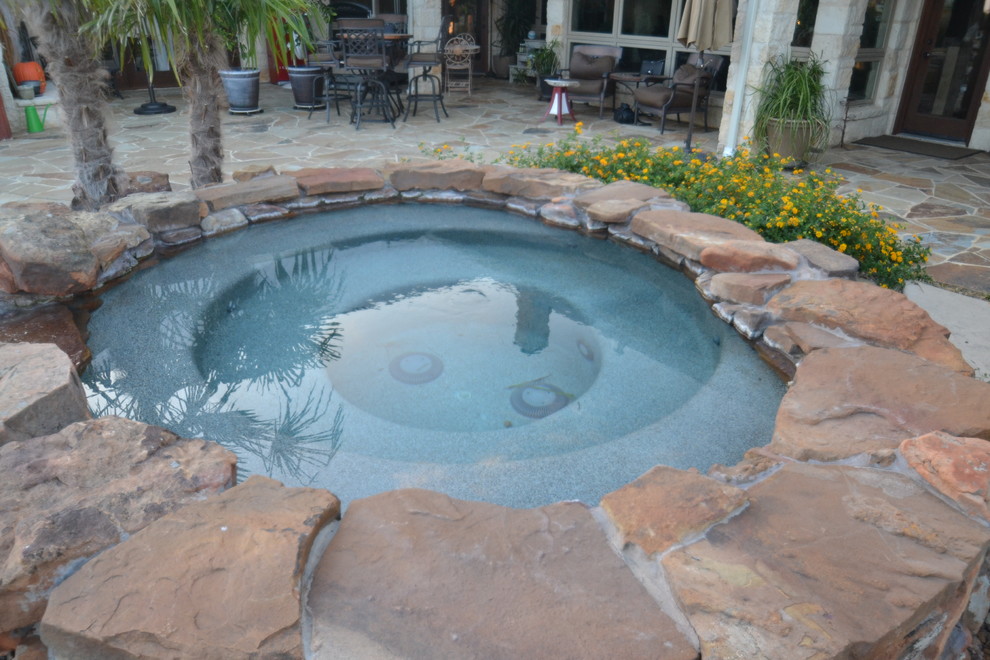 Ejemplo de piscina con fuente natural de estilo americano de tamaño medio a medida en patio con adoquines de hormigón