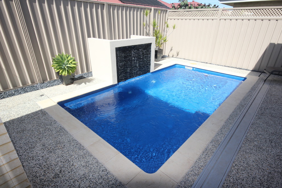 Modelo de piscina actual de tamaño medio rectangular en patio trasero