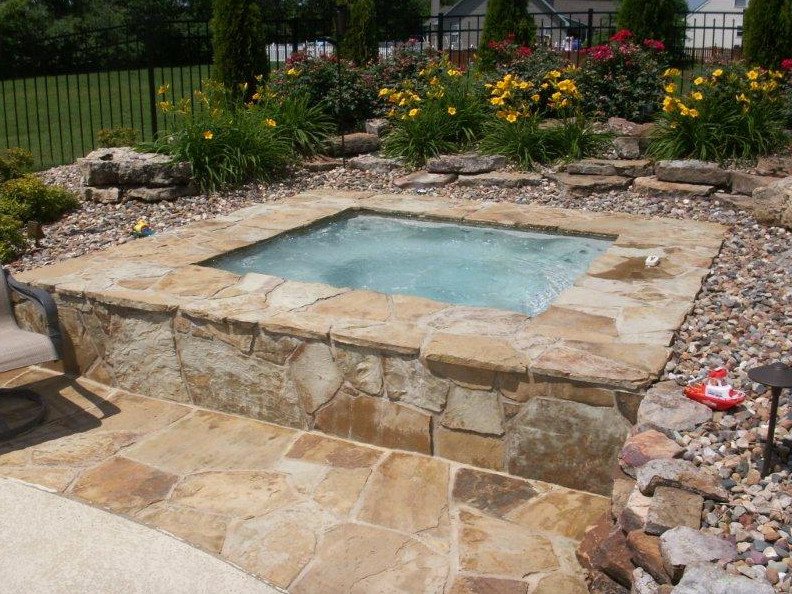 Идея дизайна: маленький прямоугольный бассейн на заднем дворе в стиле неоклассика (современная классика) с джакузи и покрытием из каменной брусчатки для на участке и в саду