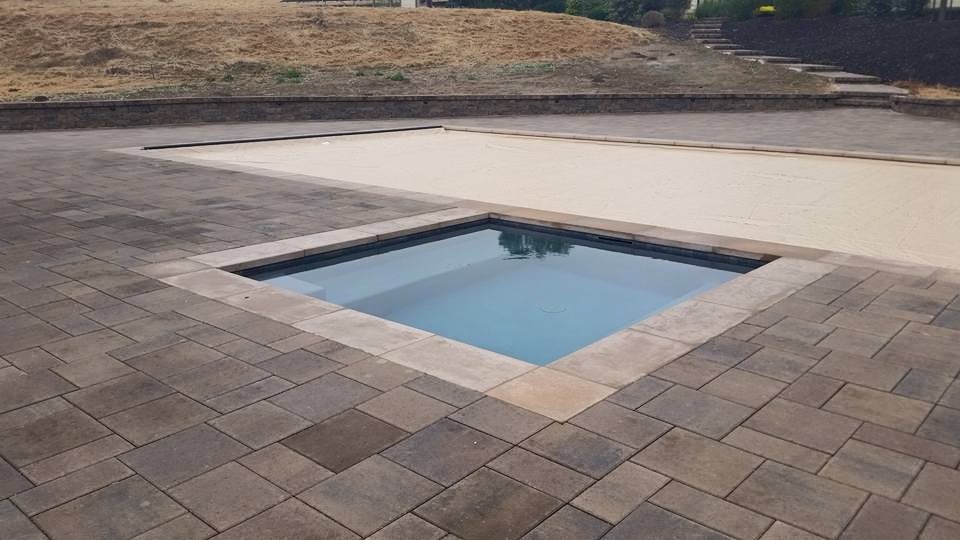 Imagen de piscinas y jacuzzis minimalistas extra grandes en patio trasero con adoquines de hormigón