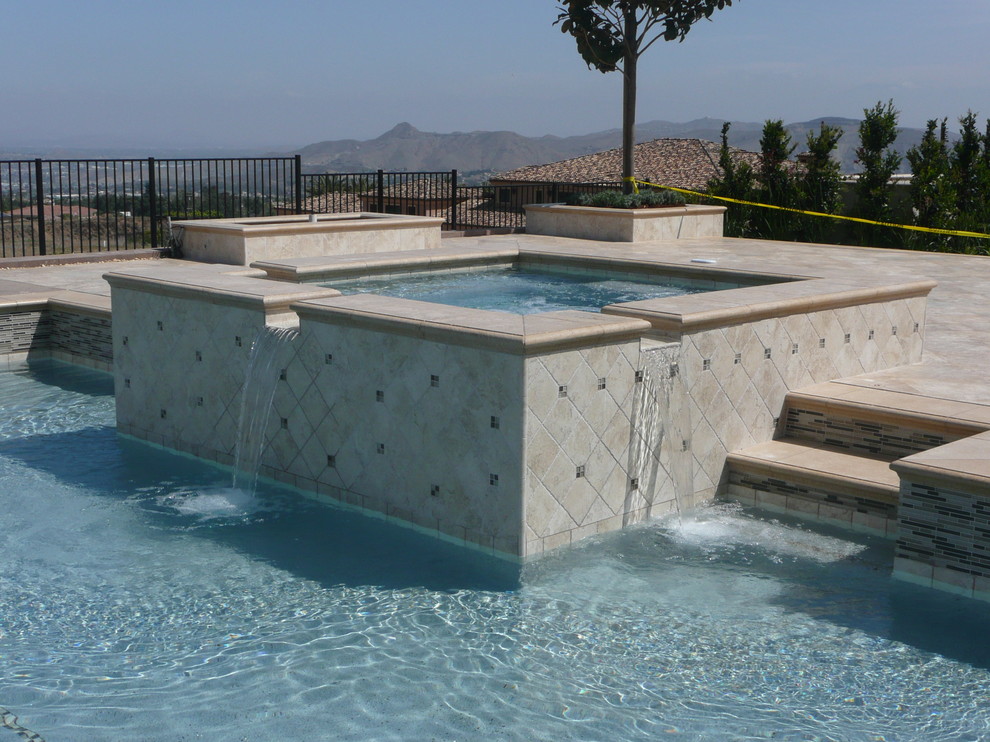 Ejemplo de piscinas y jacuzzis actuales grandes rectangulares en patio trasero con suelo de baldosas