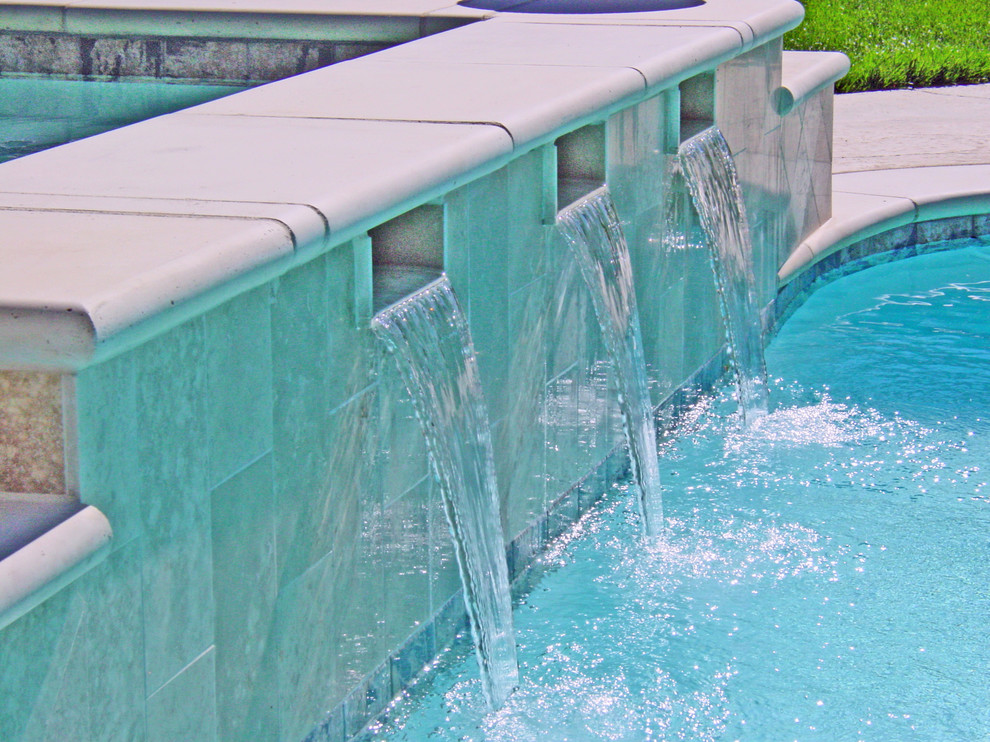 Ispirazione per una grande piscina monocorsia tradizionale rettangolare dietro casa con una vasca idromassaggio e cemento stampato