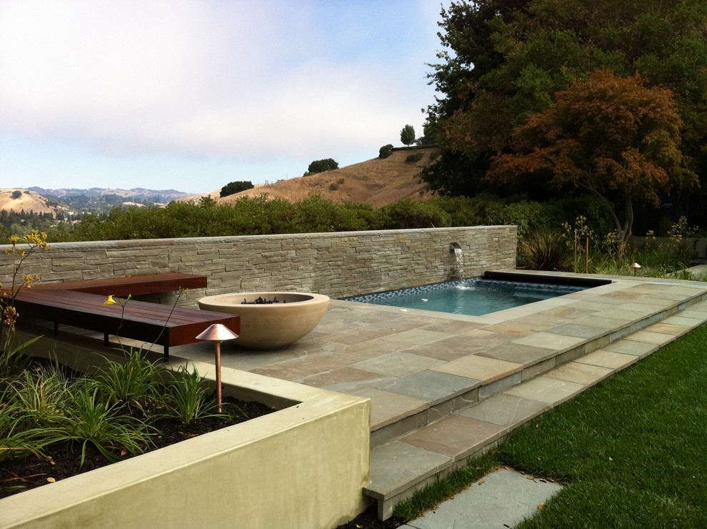 На фото: прямоугольный бассейн в стиле модернизм с покрытием из каменной брусчатки с