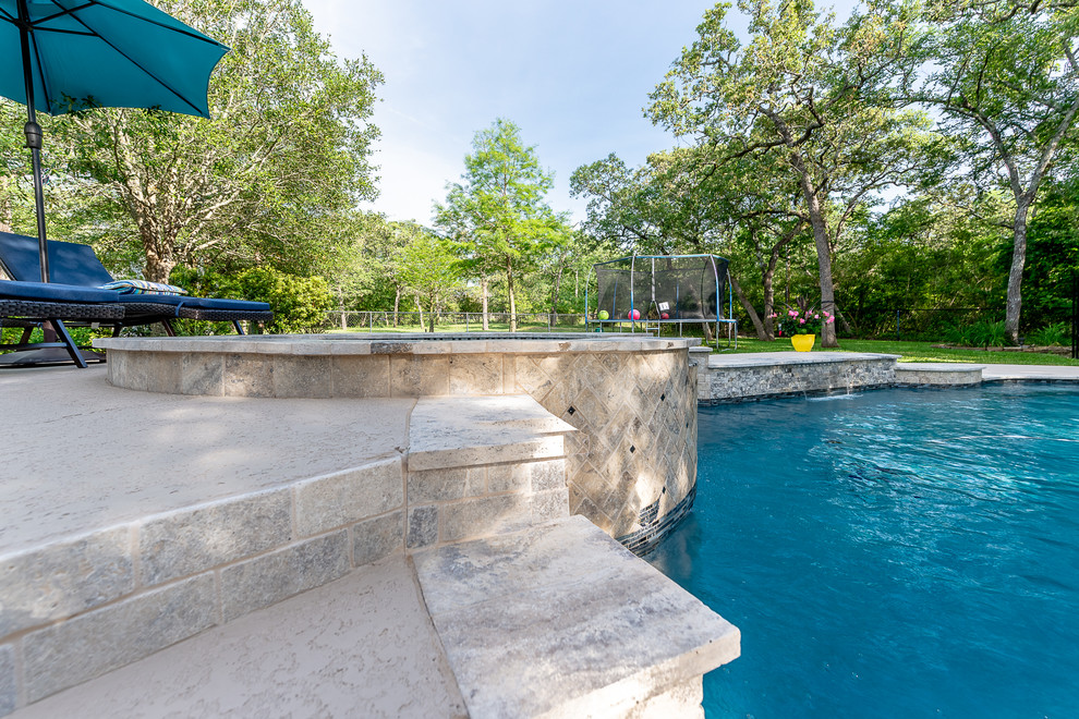 Aménagement d'une piscine naturelle et arrière exotique de taille moyenne et sur mesure avec un bain bouillonnant et une terrasse en bois.