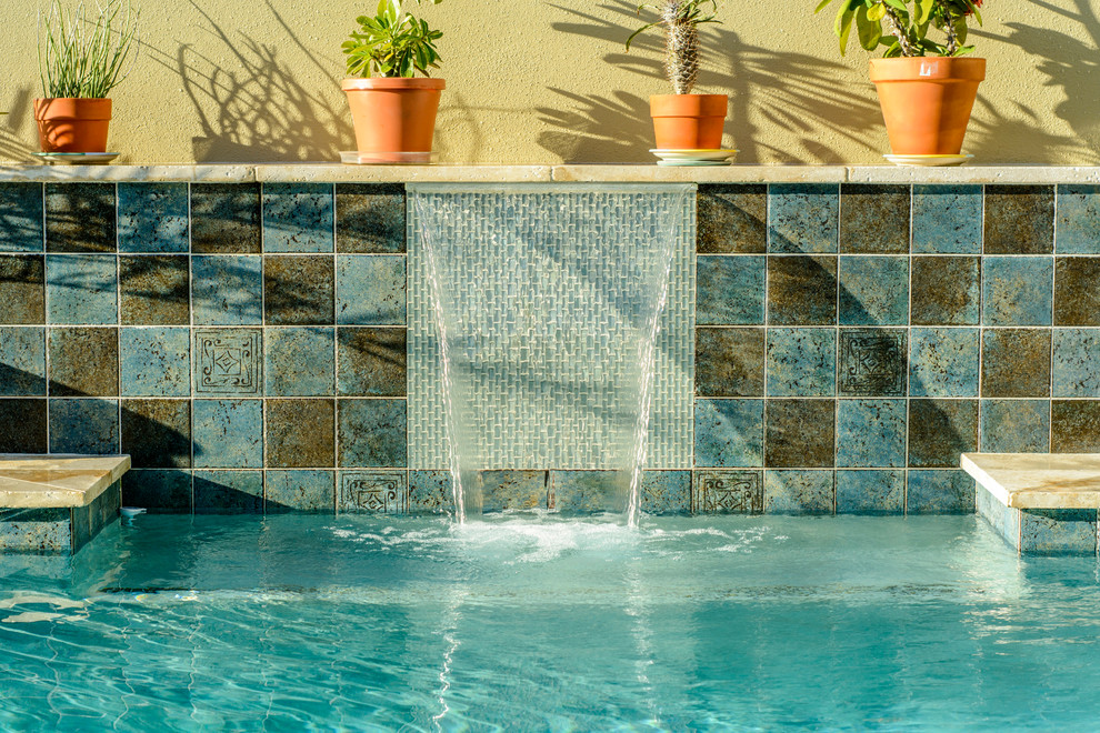 Esempio di una grande piscina monocorsia design rettangolare dietro casa con una vasca idromassaggio