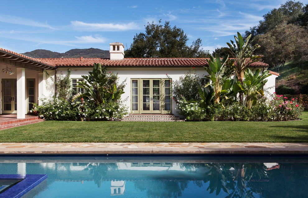 Imagen de casa de la piscina y piscina alargada mediterránea grande rectangular en patio con suelo de baldosas