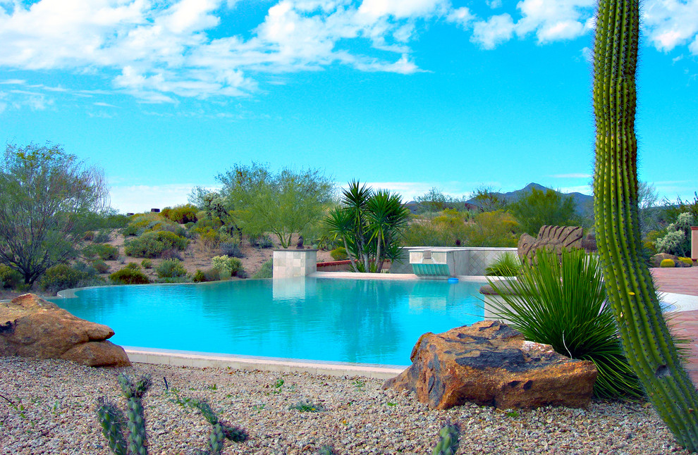 Imagen de piscina con fuente infinita de estilo americano extra grande a medida en patio trasero con gravilla