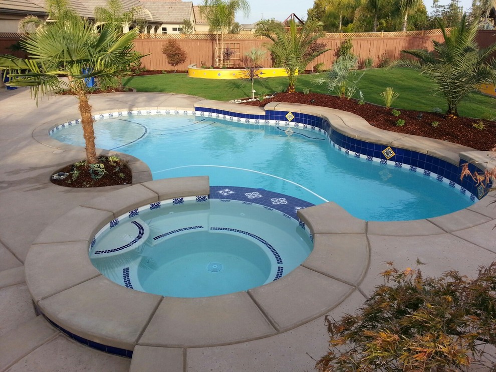 На фото: маленький естественный бассейн произвольной формы на заднем дворе в средиземноморском стиле с джакузи и покрытием из бетонных плит для на участке и в саду