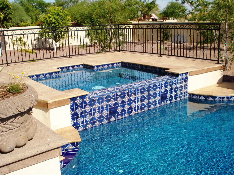 Tuscan backyard tile and custom-shaped hot tub photo in Phoenix