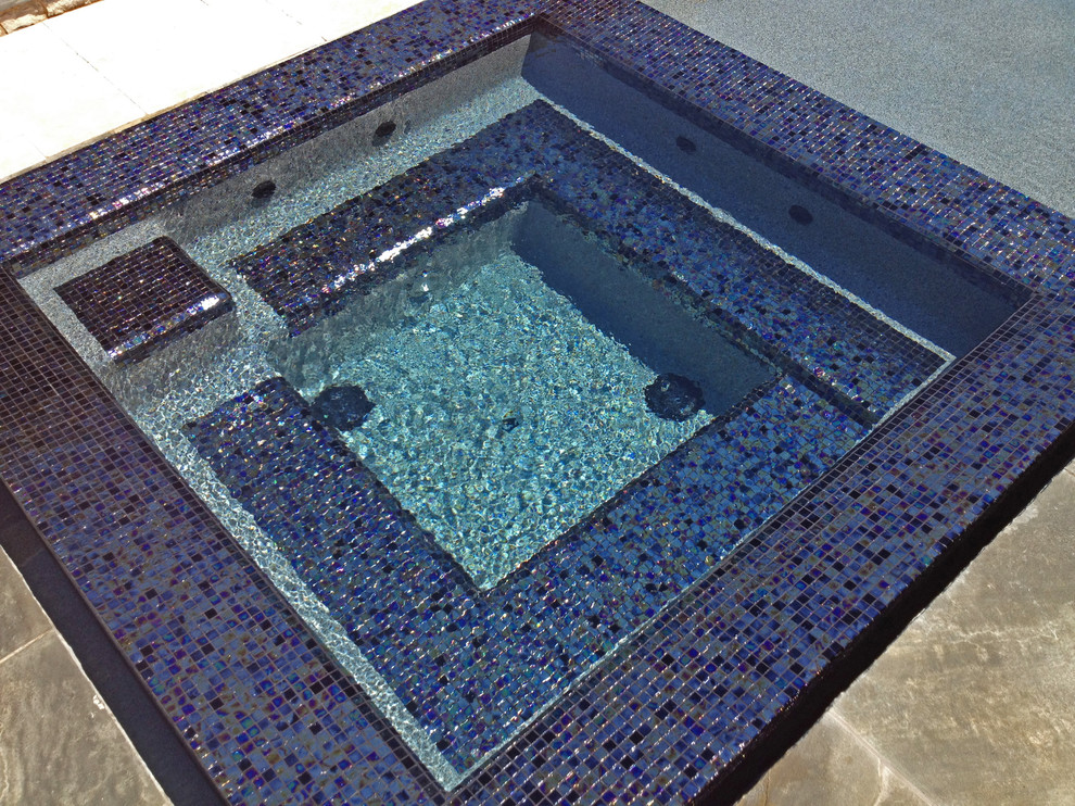 Modelo de piscinas y jacuzzis naturales mediterráneos grandes a medida en patio trasero con suelo de baldosas