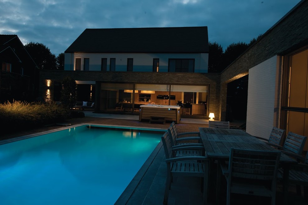Inspiration pour une grande piscine arrière craftsman rectangle avec un bain bouillonnant et une terrasse en bois.