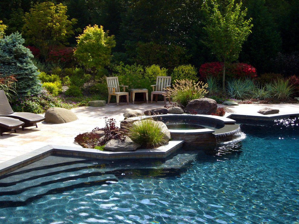 Inspiration för en amerikansk rund pool på baksidan av huset, med spabad och naturstensplattor