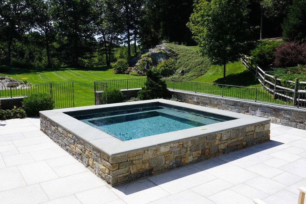 Modelo de piscinas y jacuzzis elevados minimalistas pequeños rectangulares en patio trasero con adoquines de piedra natural