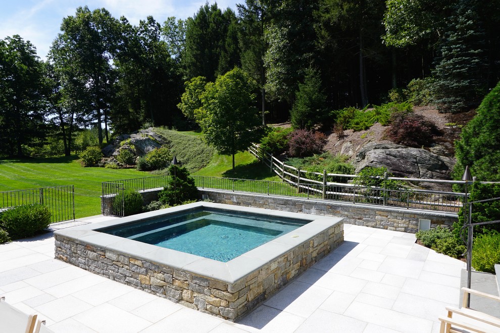 Aménagement d'une petite piscine hors-sol et arrière moderne rectangle avec un bain bouillonnant et des pavés en pierre naturelle.