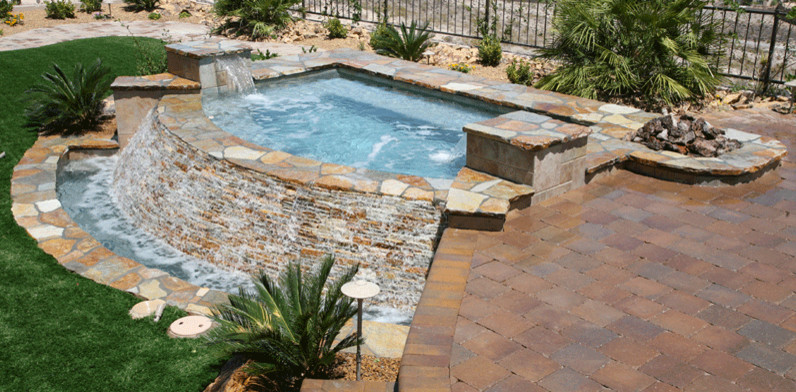 This is an example of a large back swimming pool in Las Vegas with a water feature.