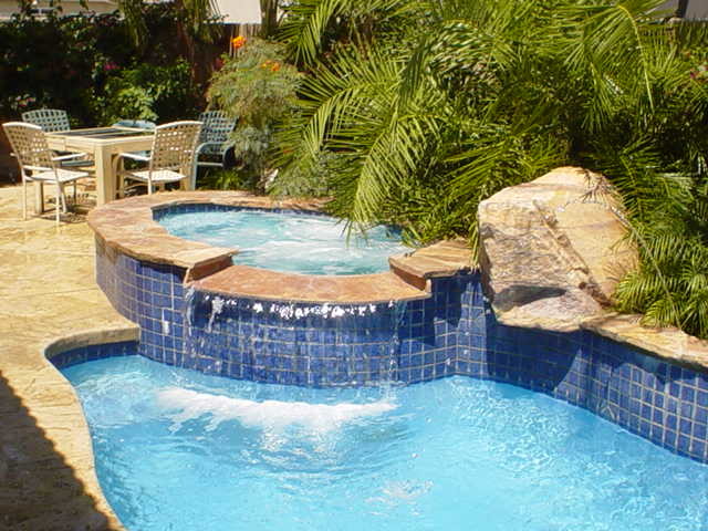Idee per una piccola piscina naturale tropicale rotonda con una vasca idromassaggio e pedane