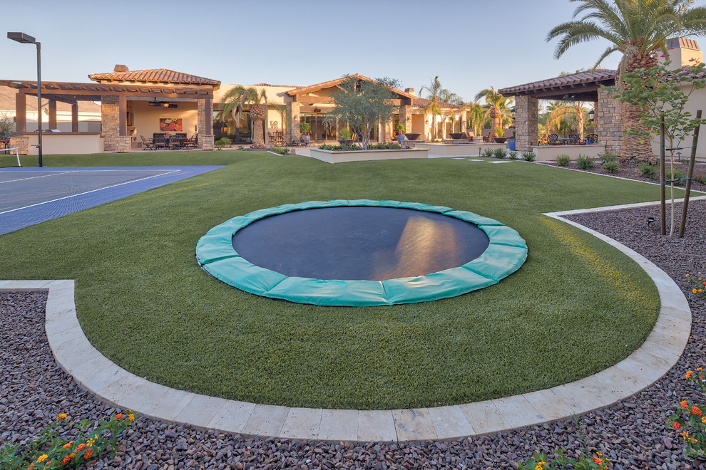 Ejemplo de piscina natural actual grande rectangular en patio trasero con adoquines de hormigón