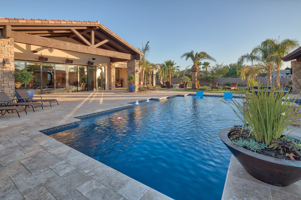 Foto de piscina natural actual grande rectangular en patio trasero con adoquines de hormigón