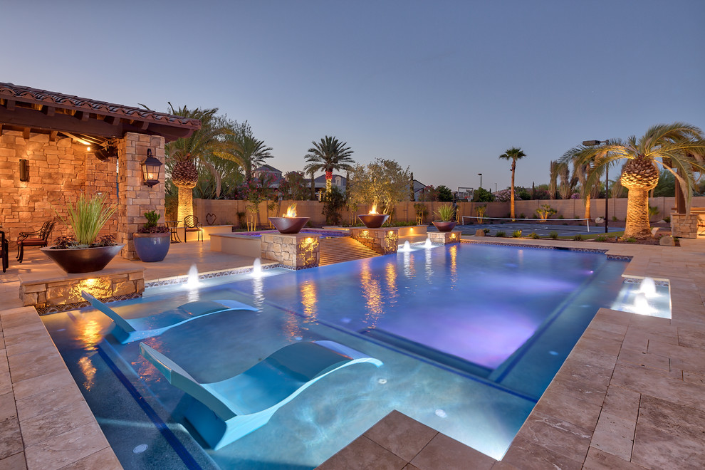 На фото: большой естественный, прямоугольный бассейн на заднем дворе в средиземноморском стиле с мощением тротуарной плиткой