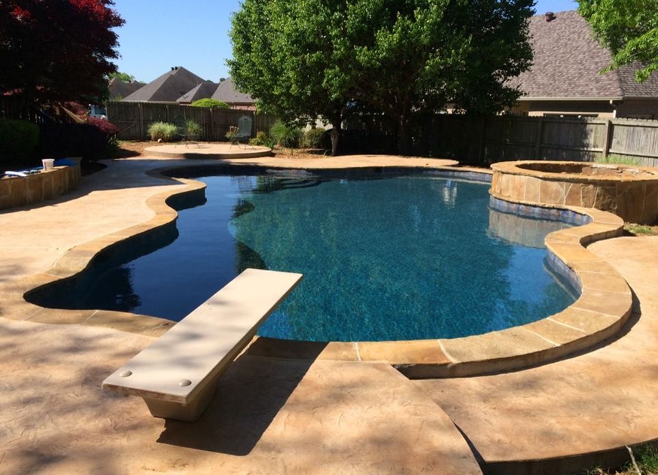 Foto de piscina con fuente tradicional grande a medida en patio trasero con suelo de hormigón estampado