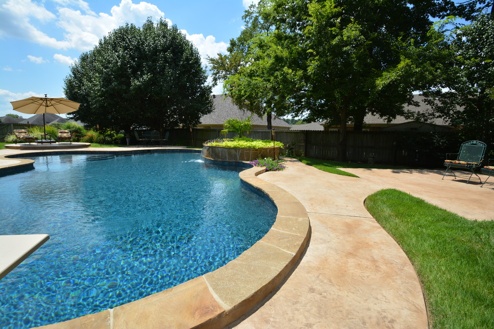 Idee per una grande piscina monocorsia chic personalizzata dietro casa con fontane e cemento stampato