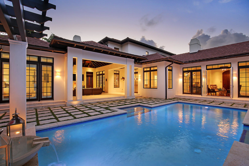 Idee per una piscina monocorsia tropicale rettangolare di medie dimensioni e dietro casa con pavimentazioni in cemento
